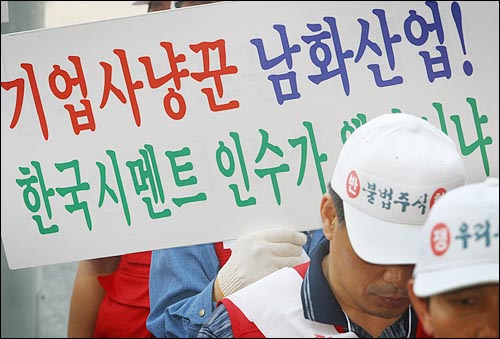 한국시멘트 종업원들이 광주시북구 누문동에 소재한 남화산업 건물 앞에서 한국시멘트 전 사장 이모씨로부터 취득한 주식을 반환하려며 시위를 벌이고 있다. 